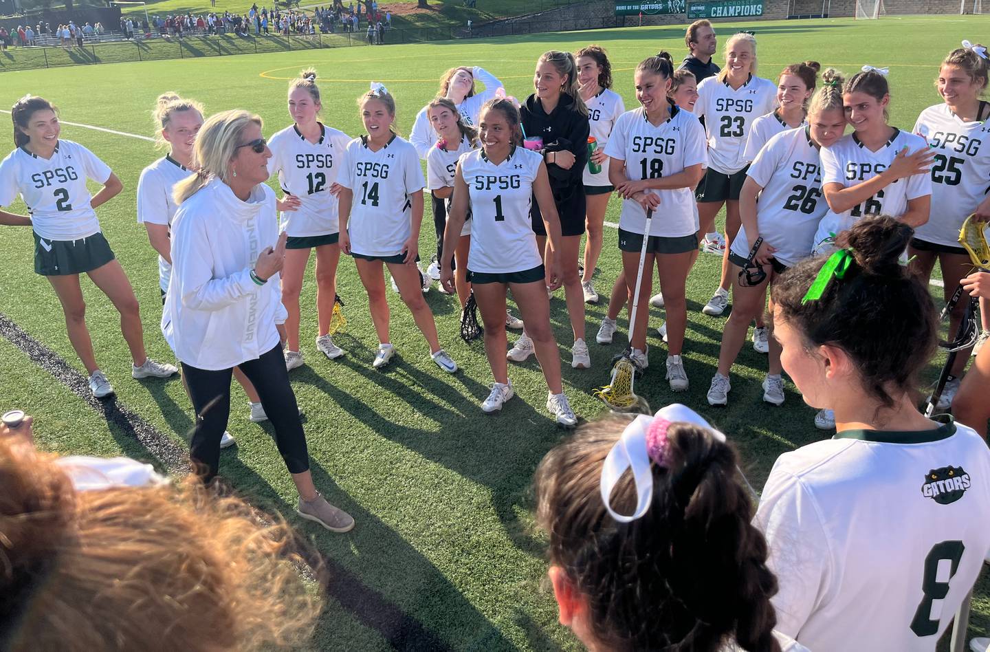 St. Paul's lacrosse coach Mary Gagnon (left in white jacket) commends her squad after Tuesday's win over Maryvale. The No. 2 Gators led wire-to-wire in a 16-4 decision over the third-ranked Lions in an IAAM A Conference semifinal.
