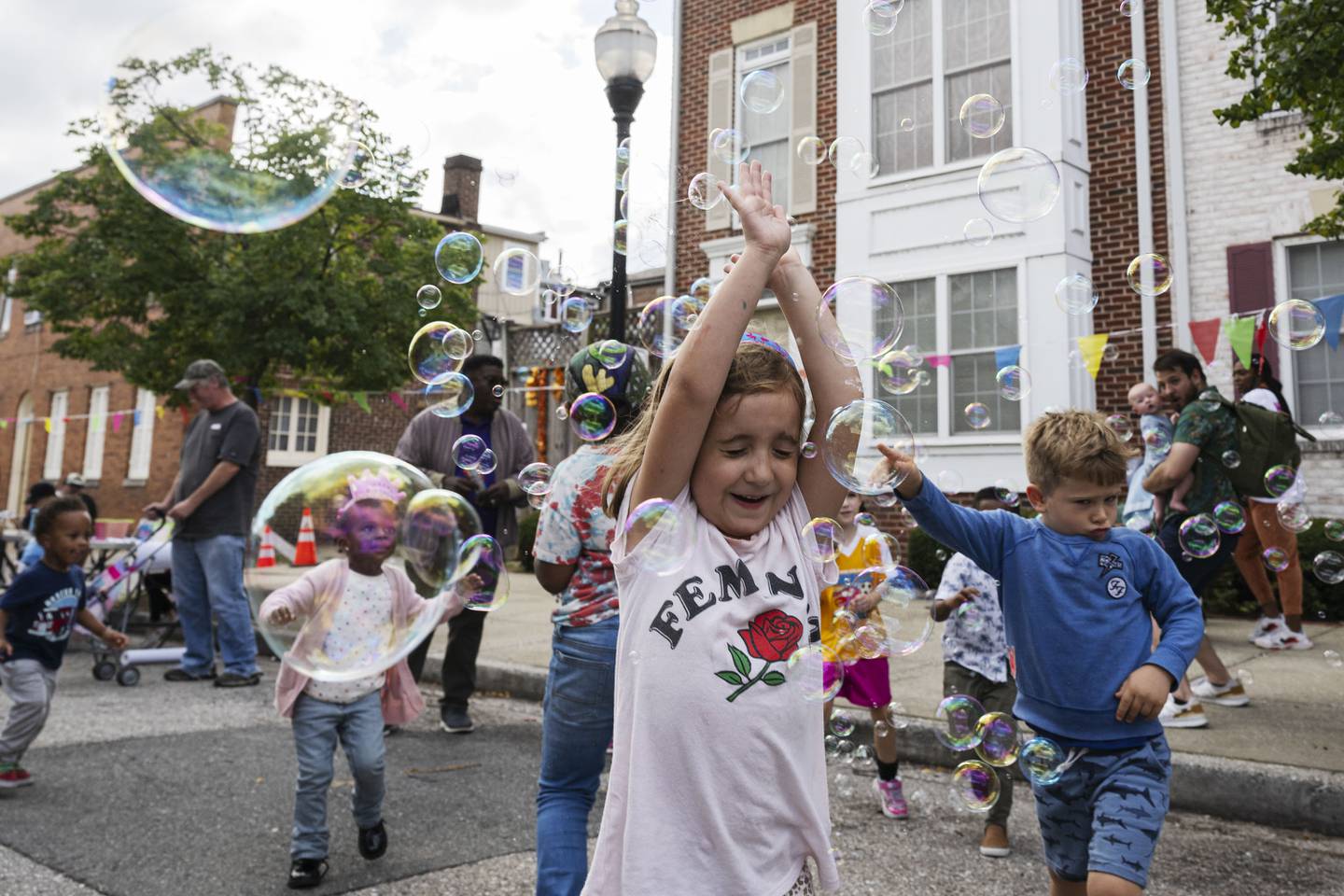 Luna Coates, 5, runs through bubbles made by Bubbleverse’s Lindsey Noel during the Pigtown Festival in Baltimore, MD on September 30, 2023. (