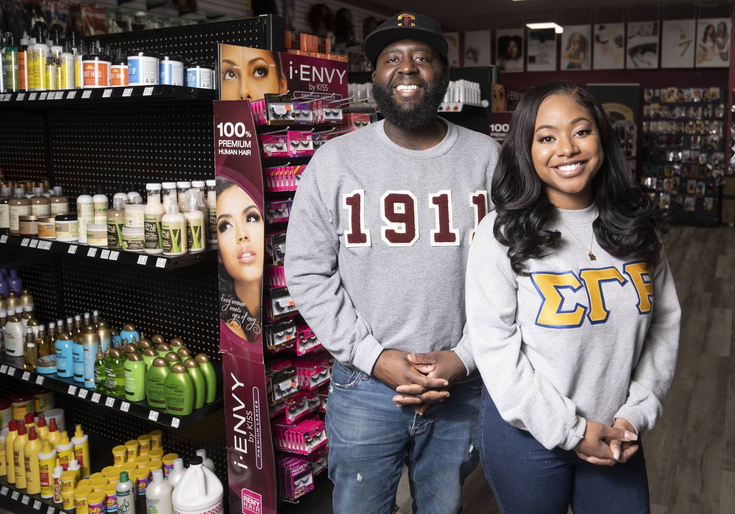 Quintin and Meghan Lathan married owners of Beauty Plus poses for a portrait inside of the shop in Baltimore, Friday, February 24, 2023.