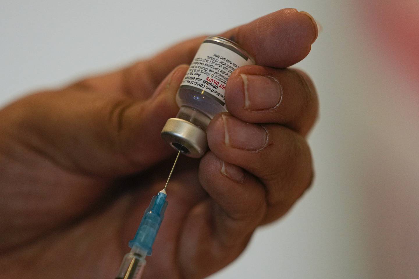 A healthcare worker prepares a dose of the COVID-19 bivalent booster at the start of a vaccination campaign for people 80 years and older, in Santiago, Chile, Wednesday, Oct. 26, 2022.