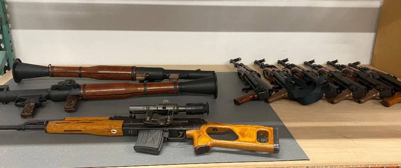 Photograph of confiscated weapons, including assault rifles.