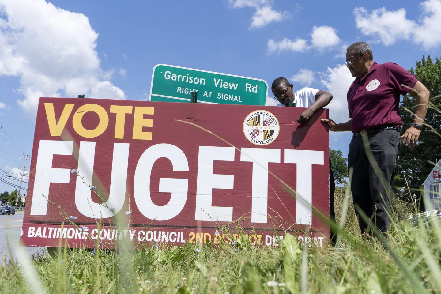 Tony Fugett and Andy Pierre install a campaign sign on Reisterstown Road.