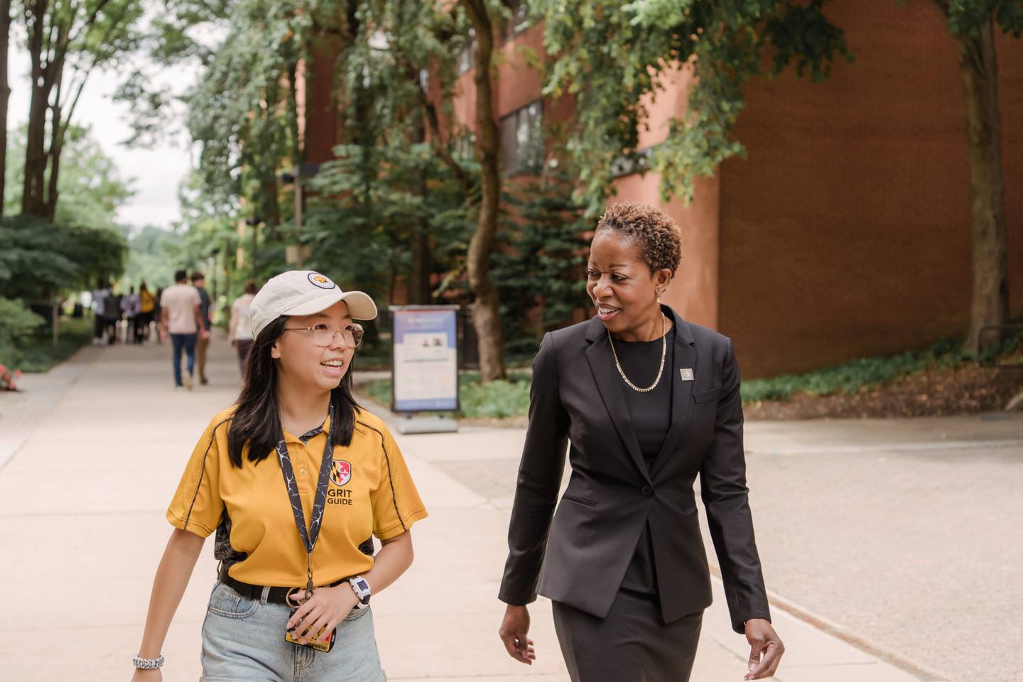 Student Sianna Serio and President Sheares Ashby walking together on campus.