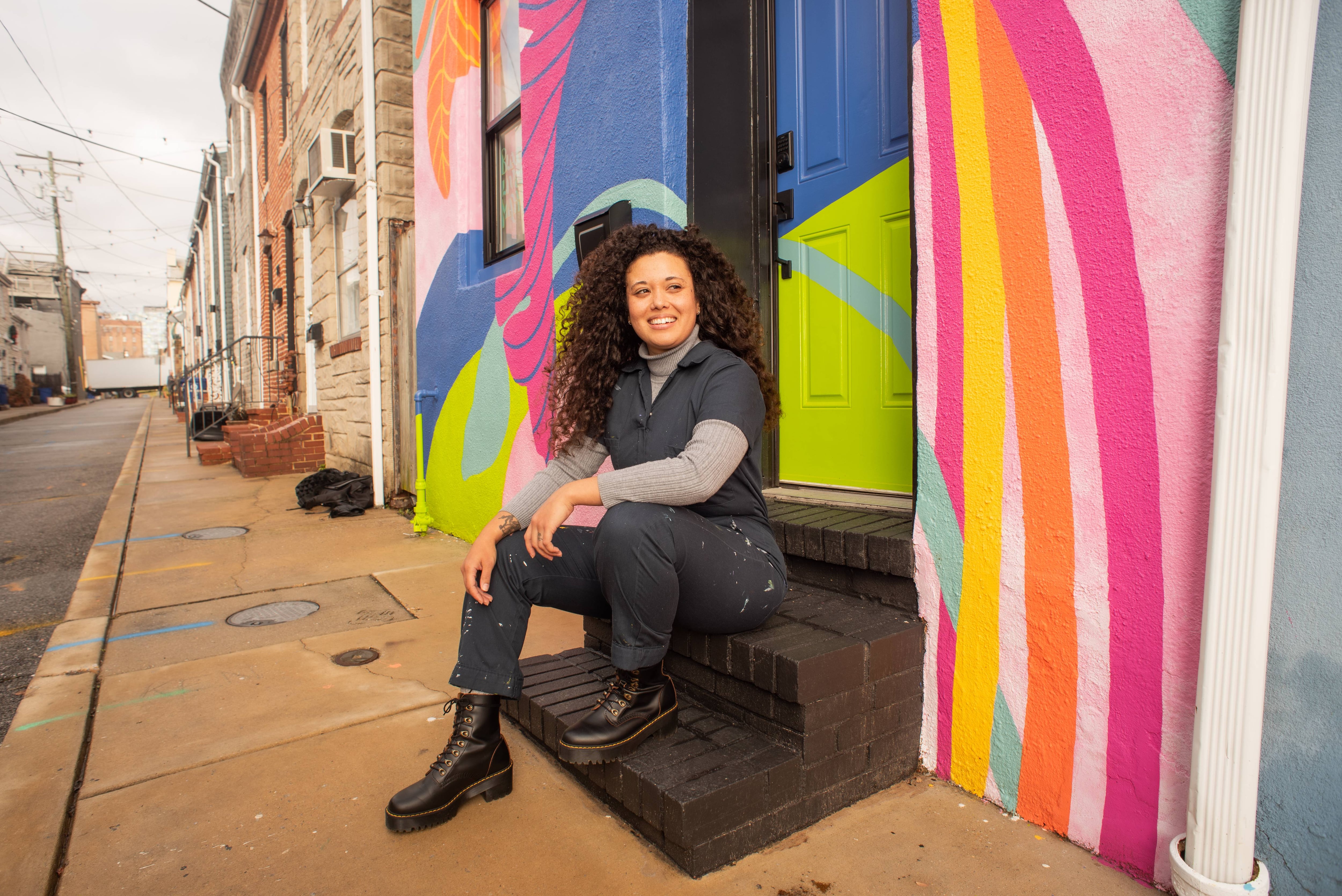 Jaz Erenberg poses for a photo outside of her rowhome that she recently painted.