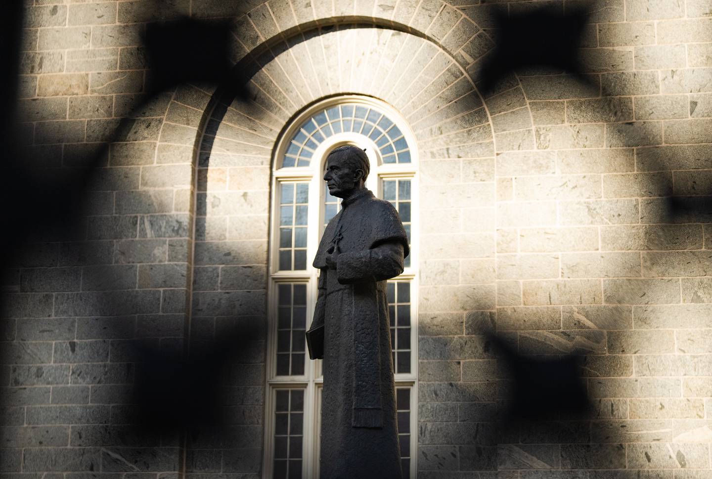 A statue of Cardinal James Gibbons stands on the side of The Baltimore Basilica, on December 2, 2022.
