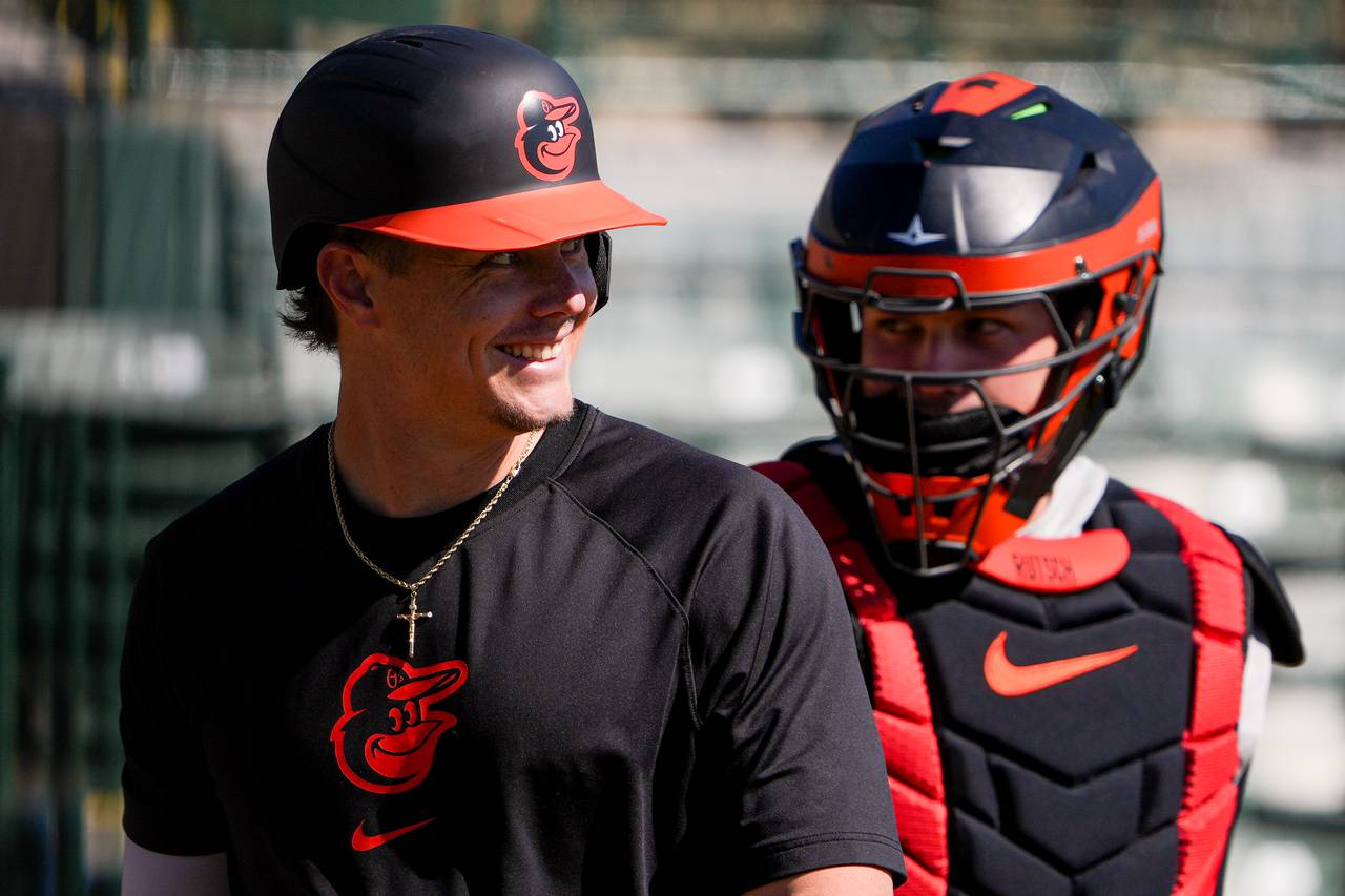 Baltimore Orioles first baseman Ryan Mountcastle, left, smiles in front of catcher Adley Rutschman as he returns to the dugout during spring training batting practice at Ed Smith Stadium in Sarasota, Florida on Monday, February 19, 2024.
