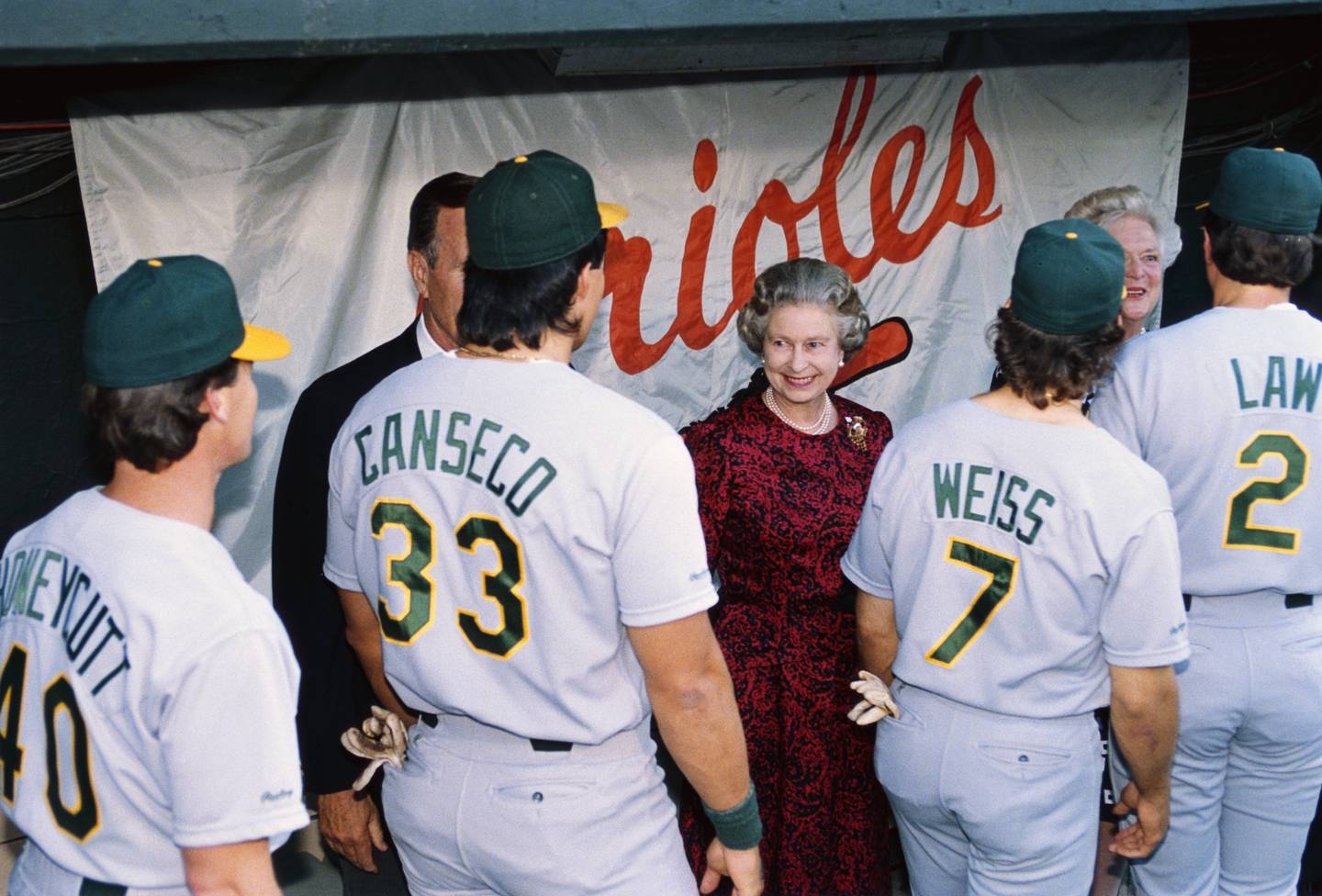 Oakland Athletics' Rick Honeycutt, Jose Canseco, Walt Weiss, and Vance Law (left to right), walk past and greet President George Bush, Queen Elizabeth II, and Barbara Bush following a game against the Orioles in Baltimore, Maryland