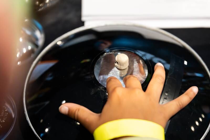A hologram optical illusion shows a floating Stormtrooper helmet as a child visitor discovers the illusion at the Jedi Mind Tricks exhibit during the Jedi Academy event at the Maryland Science Center held on May 4, 2024, in Baltimore/