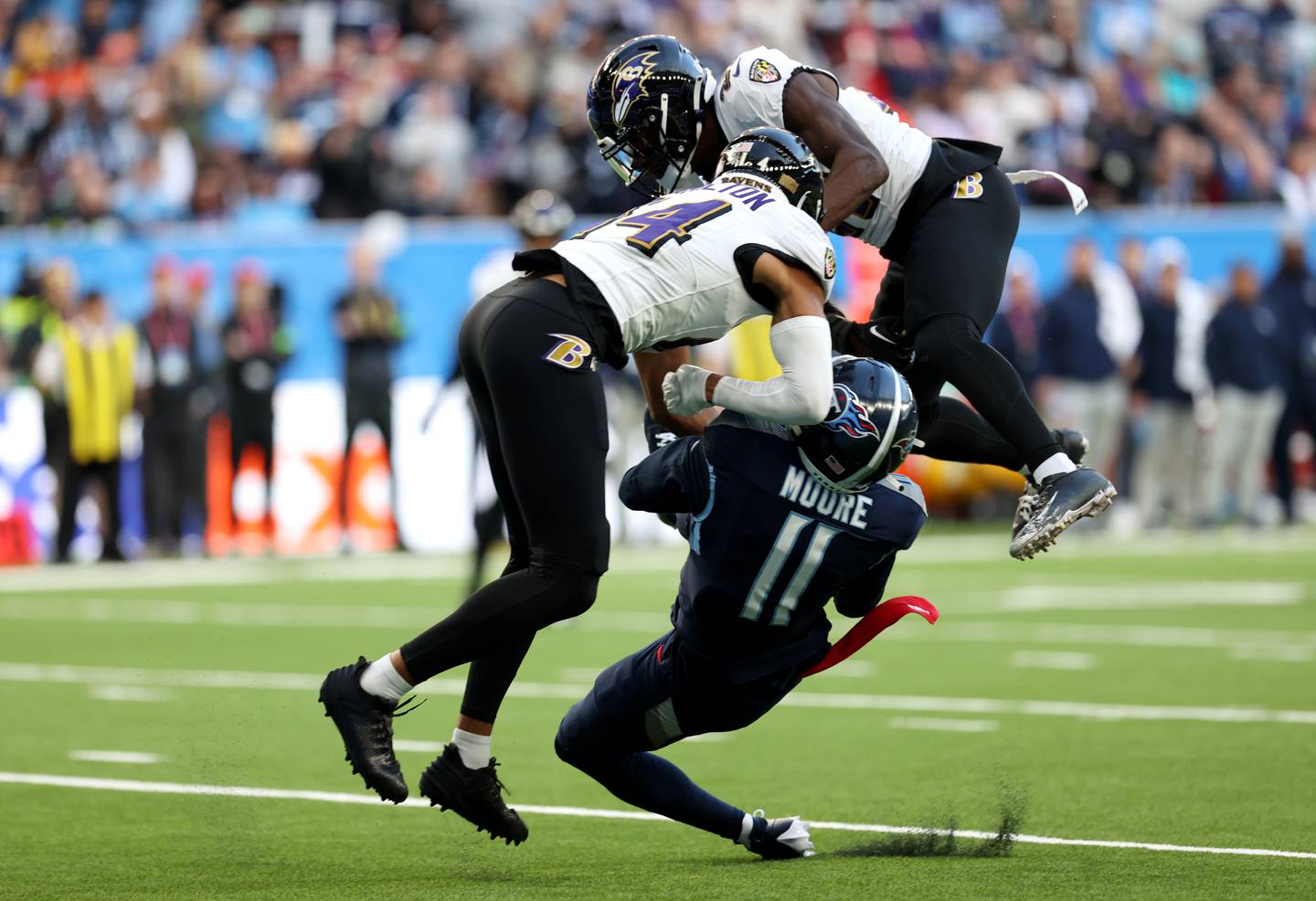 LONDON, ENGLAND - OCTOBER 15: Chris Moore #11 of the Tennessee Titans is fouled by Kyle Hamilton #14 of the Baltimore Ravens in the third quarter during the 2023 NFL London Games match between Baltimore Ravens and Tennessee Titans at Tottenham Hotspur Stadium on October 15, 2023 in London, England. (Photo by Ryan Pierse/Getty Images)