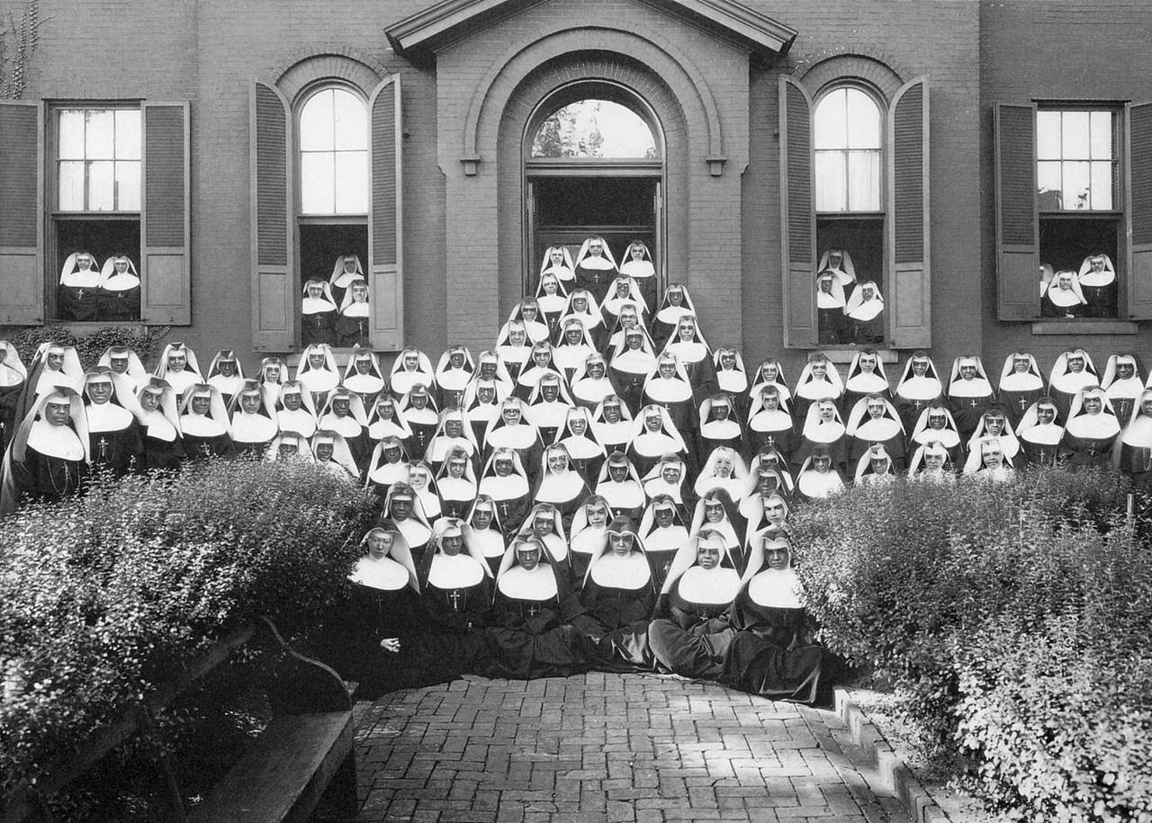 Oblate sisters pose for a portrait in front of what is Saint Frances Academy - now a coed day school on East Chase St in the city during their centennial celebration in 1929. Then it was an all girl day and boarding school, a convent (where sisters live) and a motherhouse (the headquarters for the order.)