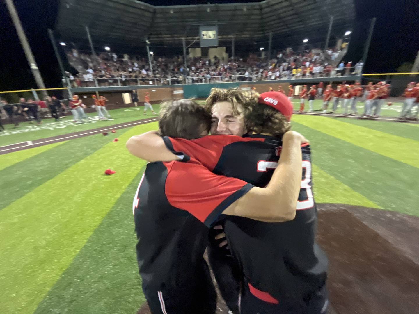 Spalding's Parker Thomas (center) is hugged by teammates after Sunday night's title clinching victory in the MIAA A Conference Tournament. In his final game, Thomas pitched a two-hitter as No. 1 Spalding defeated Calvert Hall at Joe Cannon Stadium in Harmans.