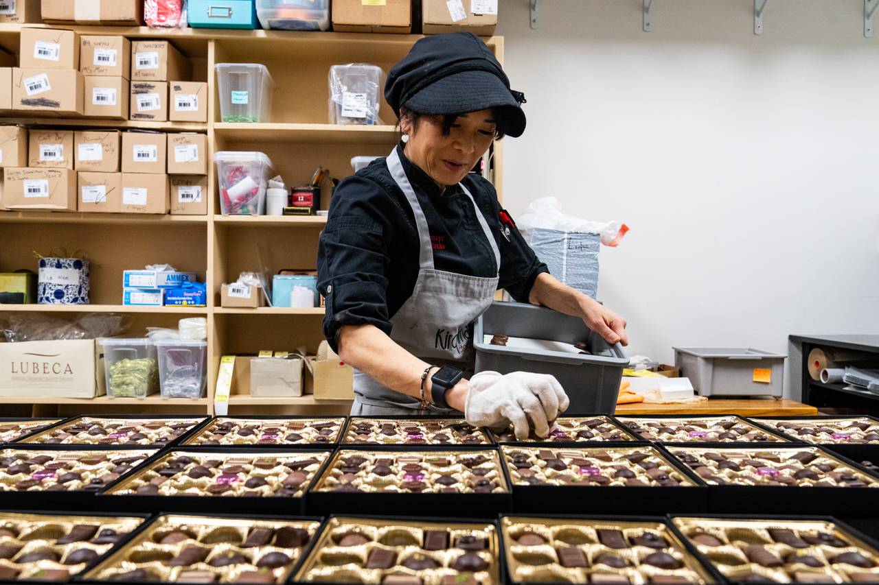 Miyoko Russell, owner of Kirchmayr Chocolatier, puts chocolates into boxes on Thursday, Dec. 14, 2023.
