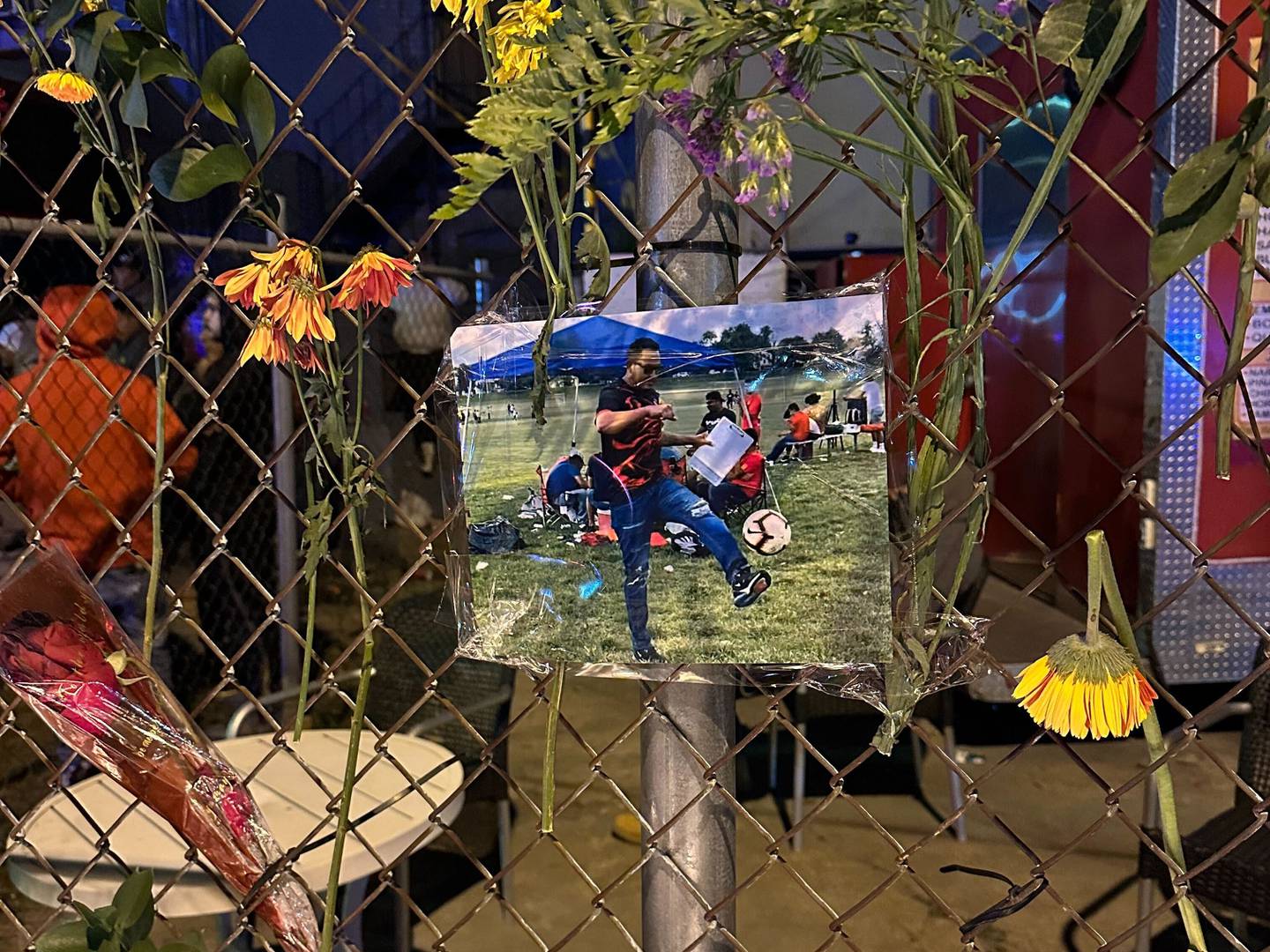 A photo of Kevin Torres hangs on a fence at a makeshift memorial at the ChrisT bar on the northern edge of Highlandtown. Torres was fatally shot by a security guard at the bar early Monday morning.
