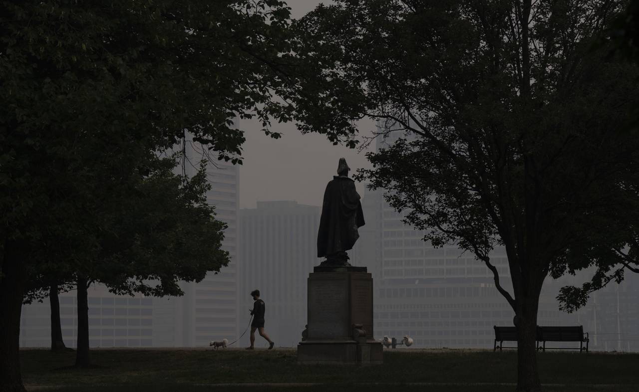 Will Simmons walks his dog, Lulu, through Federal Hill Park, in Baltimore. Air quality in Baltimore remains at dangerous levels due to smoke from Canadian wildfires blanketing the city on Thursday, June 8, 2023.