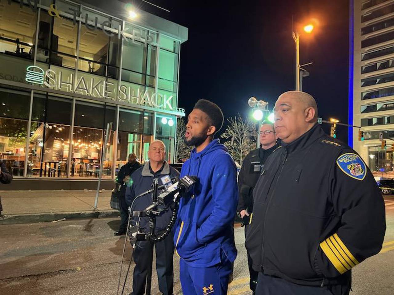 Mayor Scott, center, joined by Baltimore Police Commissioner Michael Harrison, right, and other officials, speaks at a press conference after two teens were injured in a shooting in the 400 block of East Pratt Street.