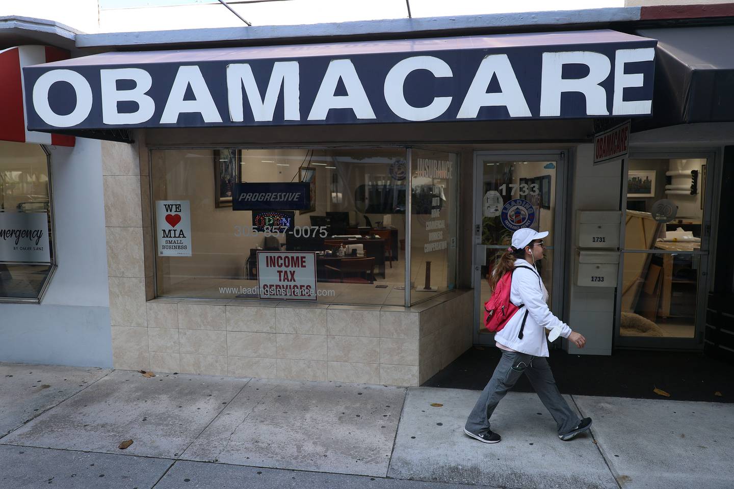MIAMI, FLORIDA - JANUARY 28: A pedestrian walks past the Leading Insurance Agency, which offers plans under the Affordable Care Act (also known as Obamacare) on January 28, 2021 in Miami, Florida.
