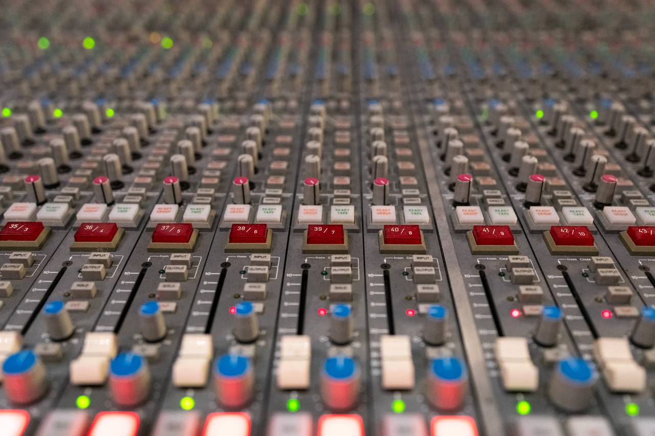 A close-up of buttons and sliders on the mixing console.
