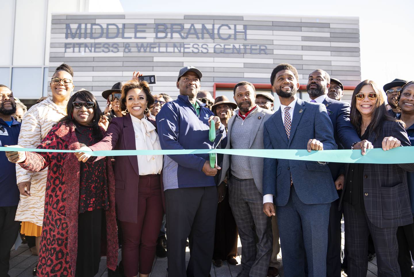 Phillip Blackwell Director of Middle Branch Fitness and Wellness Center cuts a ribbon alongside Mayor Brandon Scott and other Parks and Rec employees during the ribbon cutting ceremony for Middle Branch Fitness and Wellness Center, in Baltimore, Wednesday, November 9, 2022.