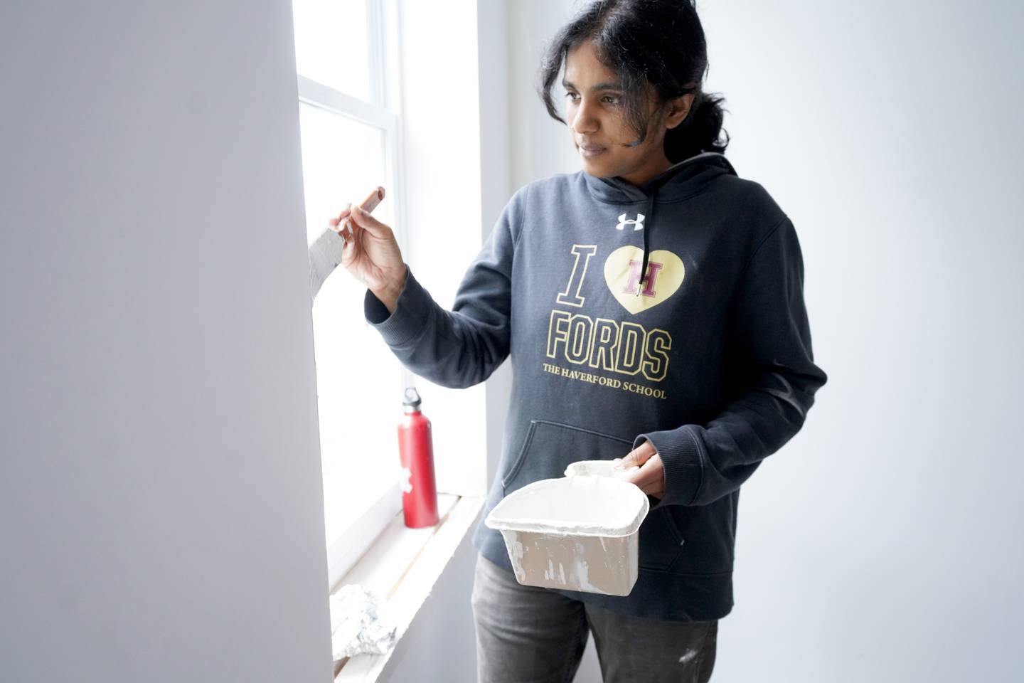 Breath of God Lutheran Church in Highlandtown renovated a vacant house that is to become a home for a new refugee family. Volunteers painted the house Friday and Saturday in hopes of having the home ready for occupancy bay February 2023.  Volunteer Anisha Jayodevan paints around the window sill.