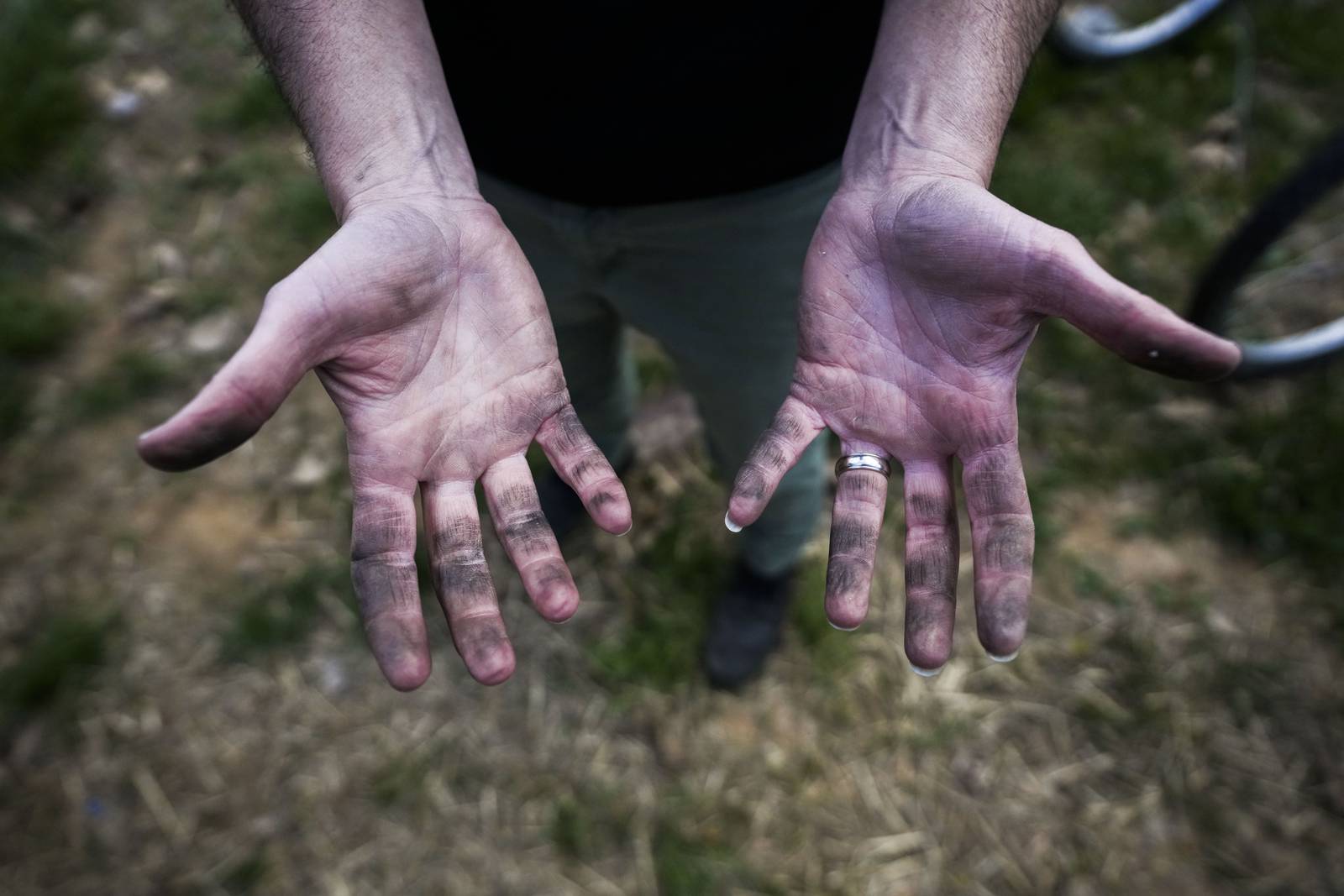 The hands of teacher August DiMucci are covered in dirt and grease from helping students with their bike engineering.