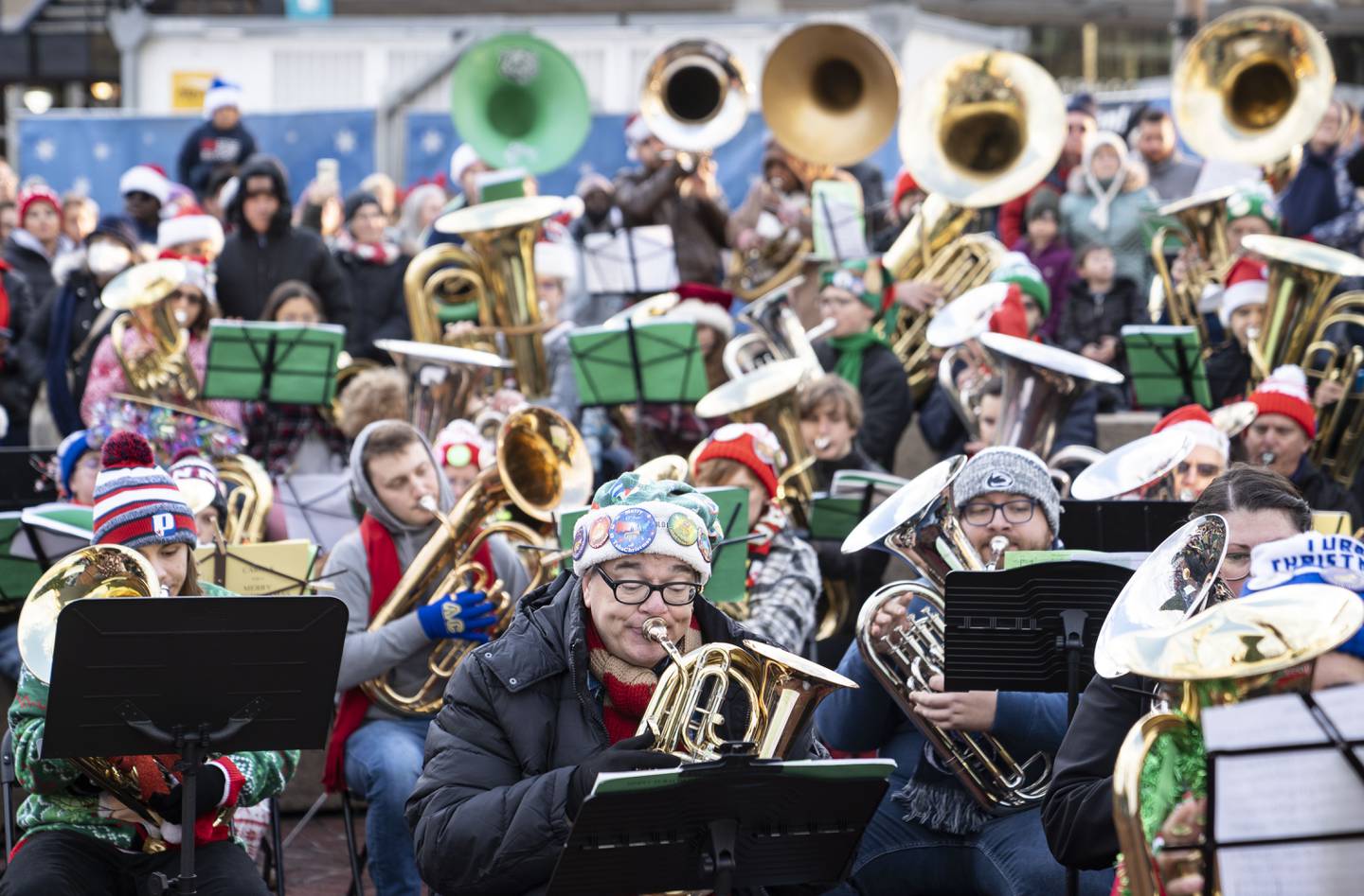 Tuba, sousaphone, and euphonium players play through a piece of music during the 37th TubaChristmas at the Inner Harbor Amphitheater, in Baltimore, Saturday, December 17, 2022