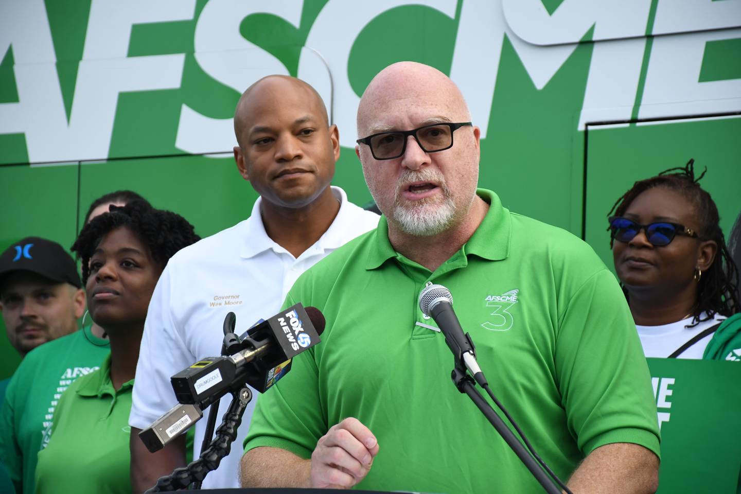 Patrick Moran, president of AFSCME Maryland Council 3, speaks at a "staff the front lines" event with members of the AFSCME union outside the union building in southwest Baltimore on Saturday, Sept. 9, 2023. Behind him is Gov. Wes Moore.