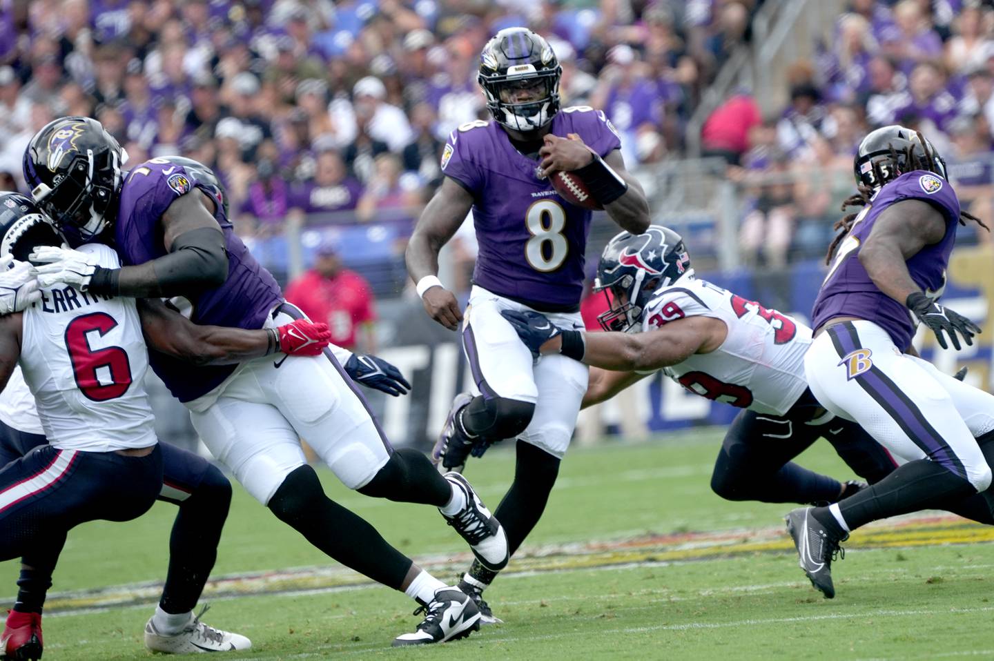Baltimore Ravens quarterback Lamar Jackson (8) scramble out of the pocket and teh grasp of Texans' #39 Henry To'oTo'o in the Ravens 25-9 victory over the Houston Texans at the M&T Stadium Sept. 10, 2023.