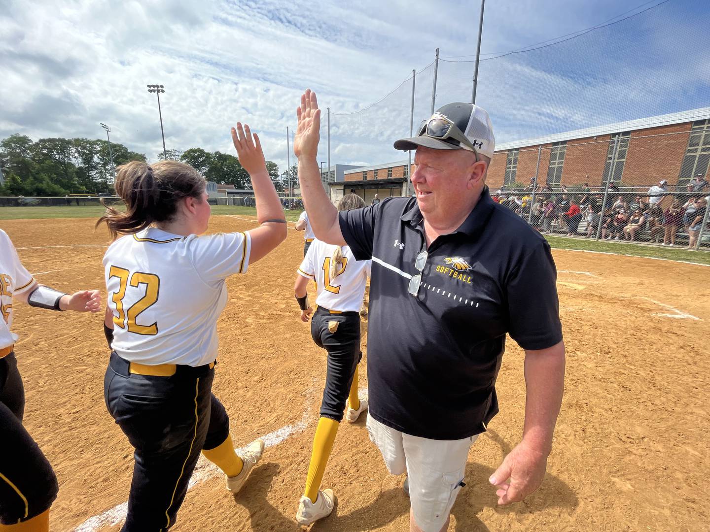 Northeast softball coach Joe Hart (left) high-fives Kayleigh Fyffe after Saturday's Class 2A state quarterfinal contest against Carver A&T. The No. 3 Eagles advanced to their first state semifinal since 2017 with a 3-2 victory over the 14th-ranked Wildcats in Pasadena.