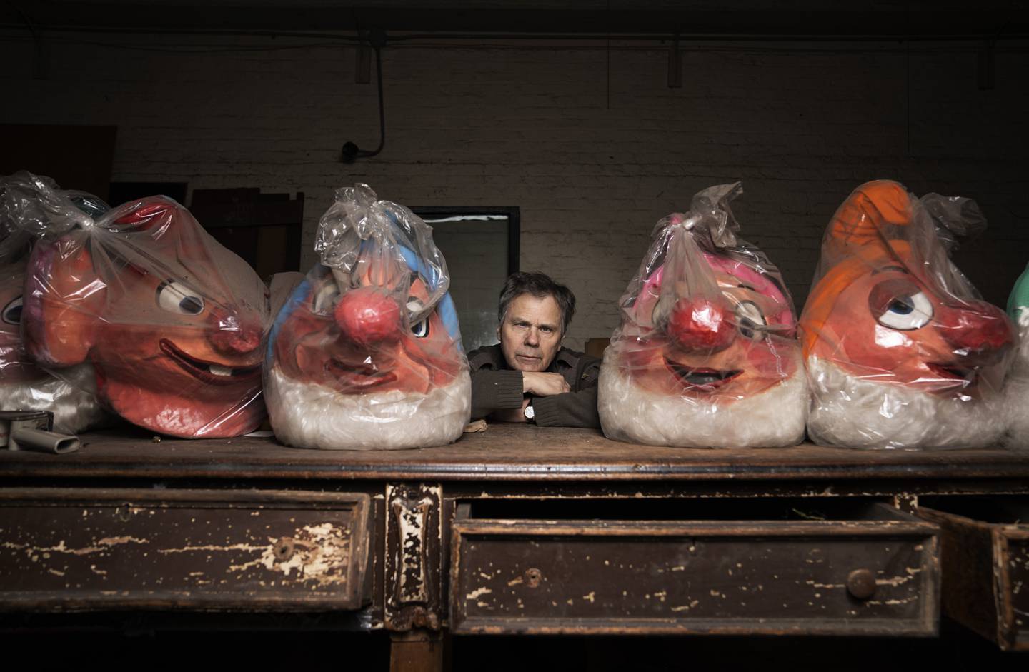 Rick Goebel is flanked by two papier-mâché heads of the dwarves from "Snow White."
