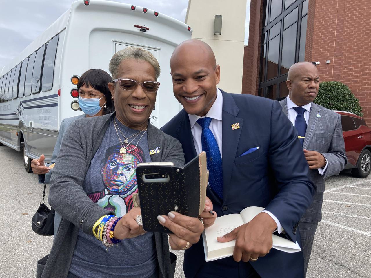 Maryland's Democratic nominee for governor Wes Moore poses for a selfie with Gwendolyn Briley-Strand while signing a book for her outside Mt. Ennon Baptist Church in Clinton on Sunday, Nov. 6, 2022. Ahead of Tuesday's Election Day, candidates are busy making their final pitches to voters.
