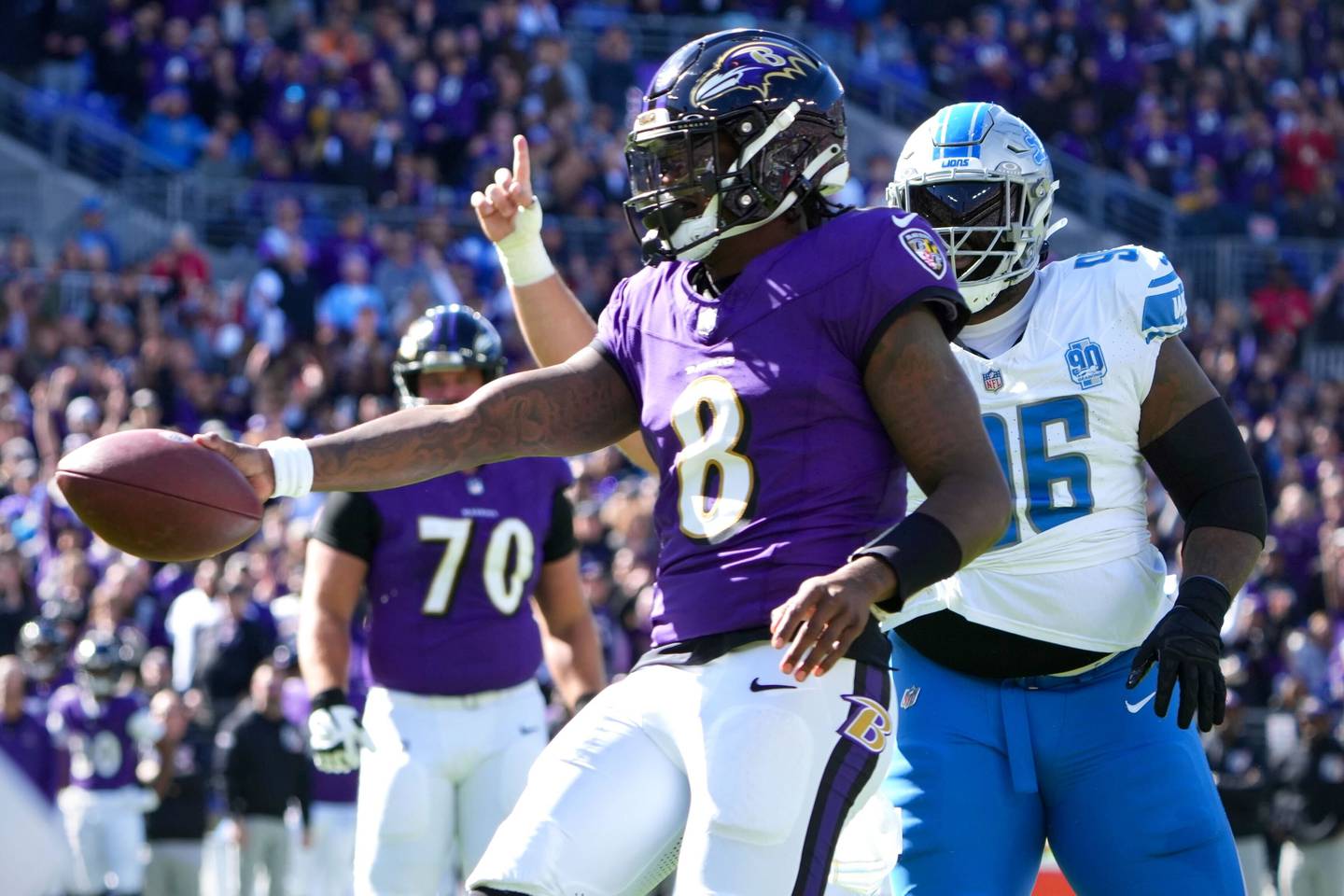 Ravens QB Lamar Jackson extends the ball as he crosses the line to score a touchdown in the first half of Baltimore's 38-6 win against the Lions at M&T Bank Stadium.