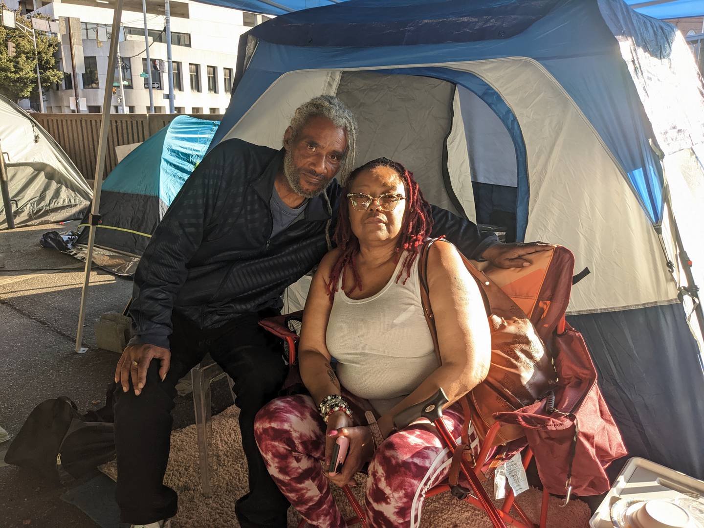 Michael and Rose Young pose for a picture in front of their tent on Friday, Oct. 7, 2022. They are residents of a homeless encampment under the Jones Fall Expressway.