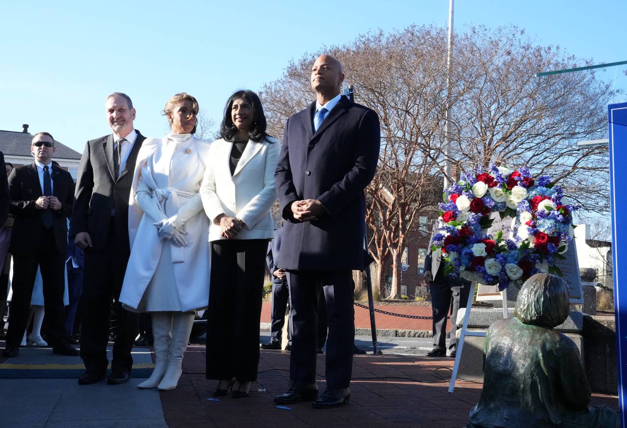 Dawn Flythe Moore, Aruna Miller and Wes Moore standing at the Kunta Kinte-Alex Haley Memorial to lay a wreath and say a prayer before the governor-elect is sworn in as the first African American governor of the state of Maryland.