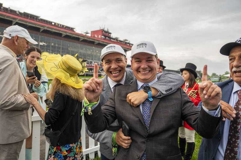 Members of the owner group for Seize the Gray, celebrate after he wins The Preakness Stakes.
