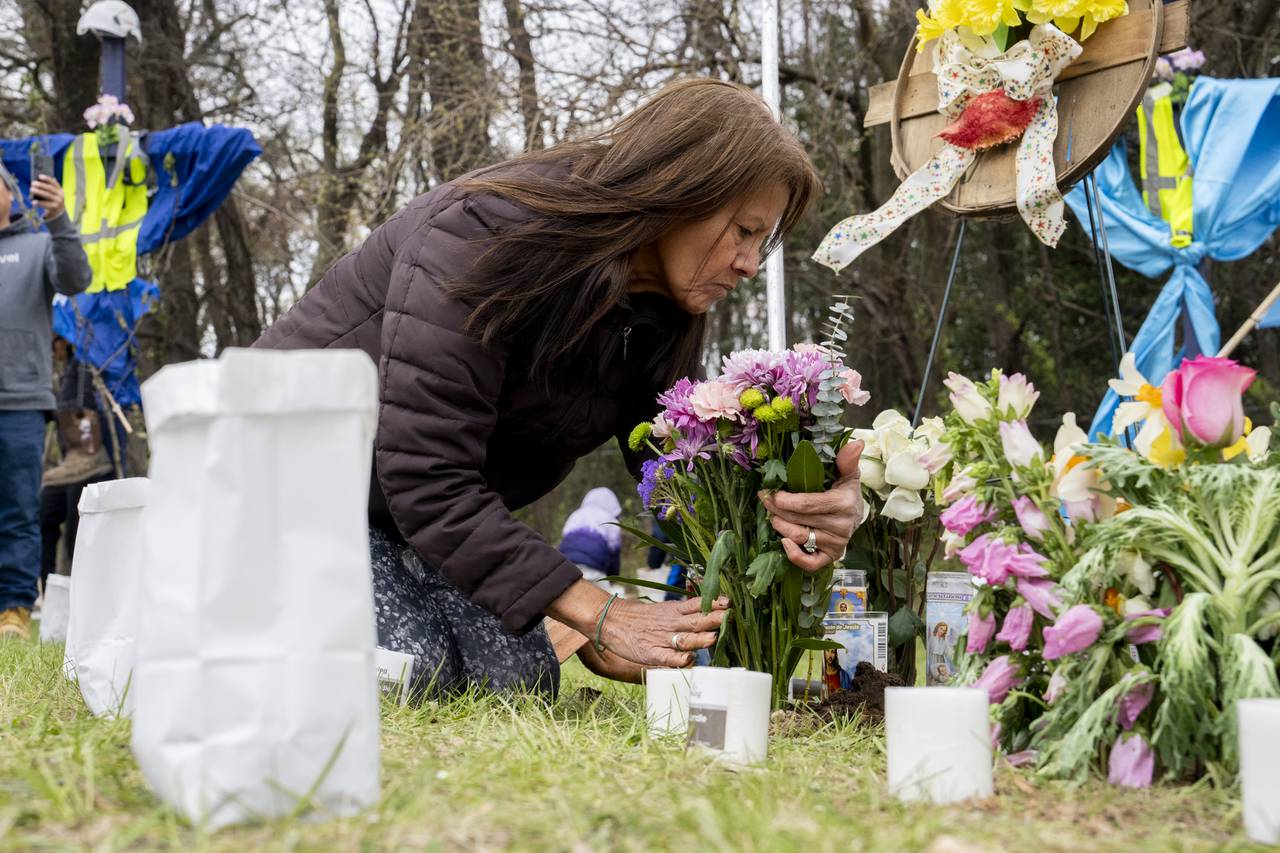 Elisa Salcedo lays flowers in front of the memorial site to honor the construction workers who lost their lives in the collapse of the Key Bridge.