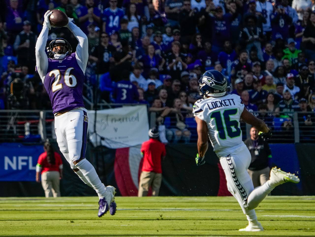Baltimore Ravens safety Geno Stone (26) catches an interception during the second quarter against the Seattle Seahawks at M&T Bank Stadium on Sunday, Nov. 5, 2023.