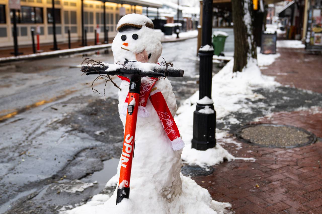 A snowman, smoking a cigarette and sticking out its deli meat tongue, rides a scooter in Fells Point on Tuesday, Jan. 16, 2024. Baltimore received about 4 inches of snow.