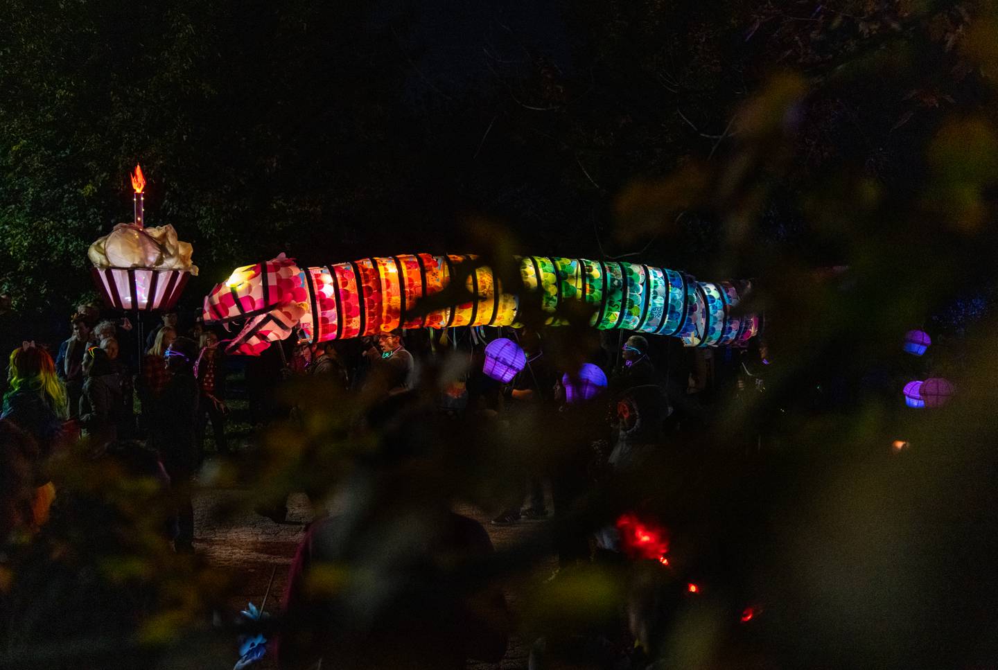 A creature chases a cupcake during The Great Halloween Lantern Parade at Patterson Park on Saturday, Oct. 21, 2023.