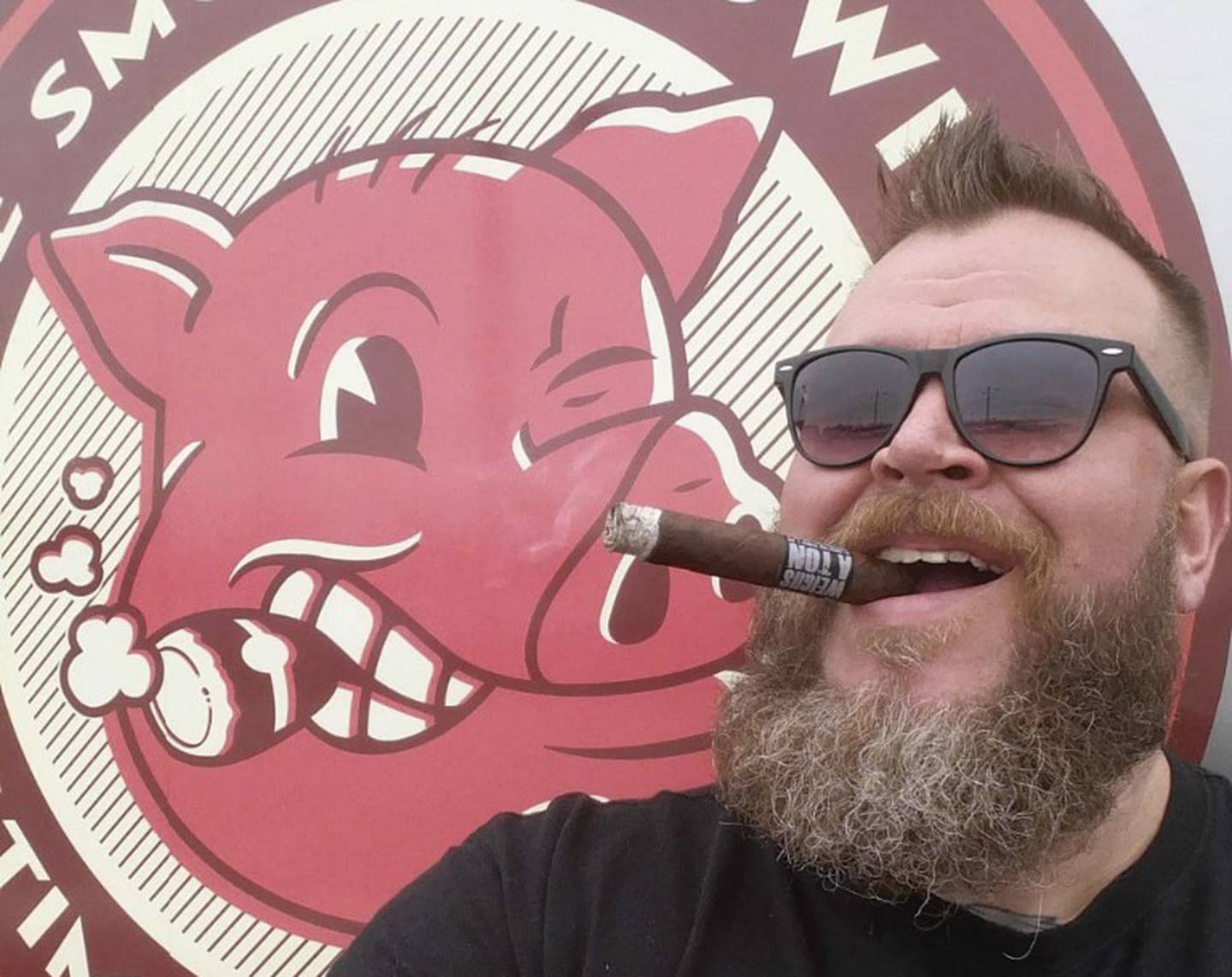 L. Drew Pumphrey appears outside his Smoking Swine food truck, chewing on a cigar.