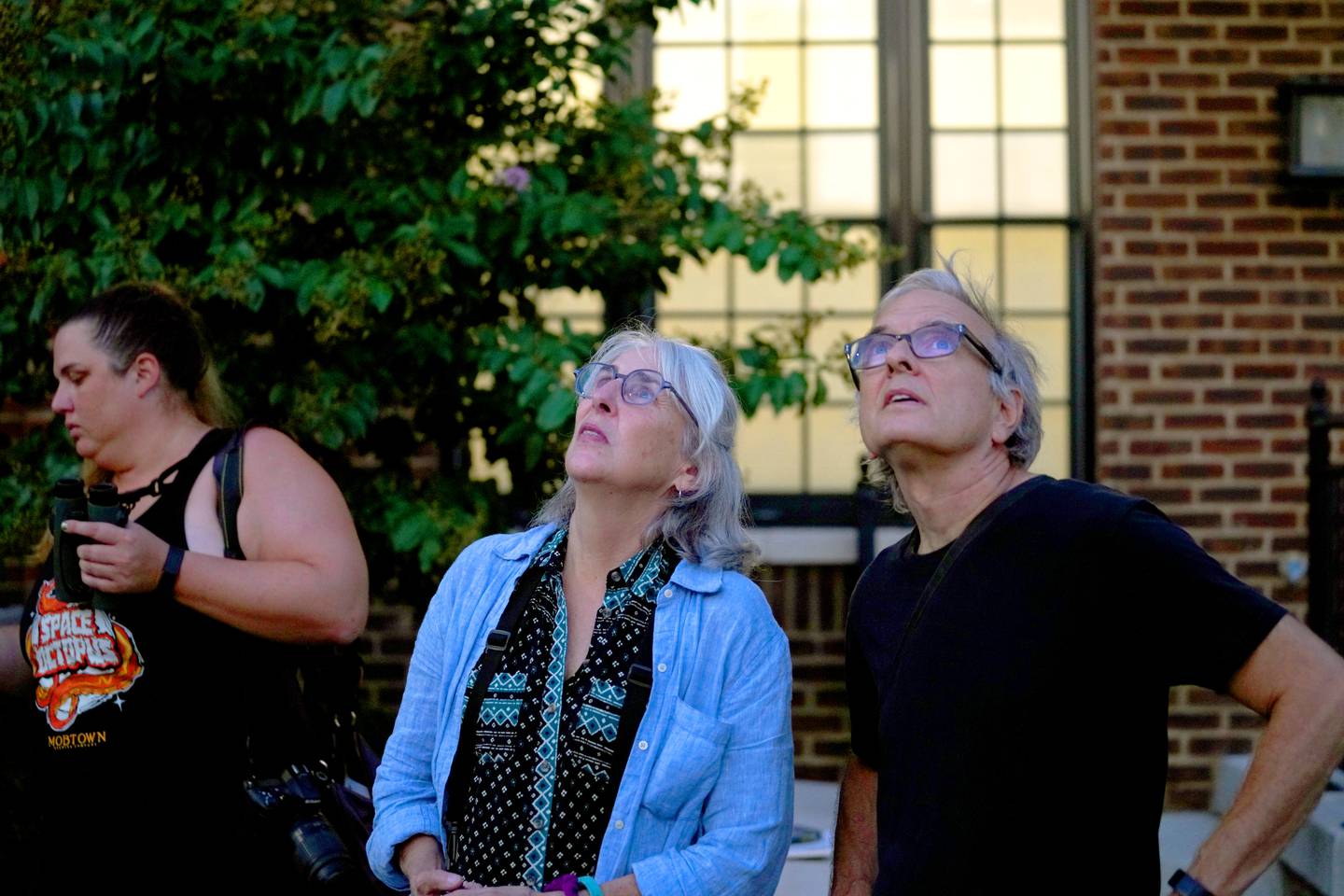 (L to R) Libby Erickson, Alice Greely-Nelson and husband David Nelson gather to watch the chimney swifts gather for the night  in Hampden's old bookbindery as they journey from Canada to South America. This year, could be the last as the building has been purchased and possibly slated for demolition.