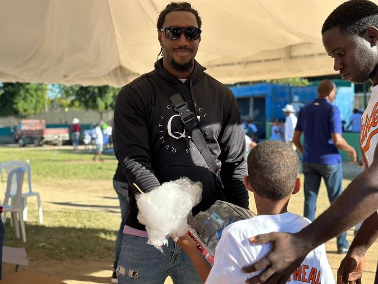 Orioles utilityman Jorge Mateo gives a toy to a child in San Luis, Dominican Republic. Each winter, Mateo hosts a donation drive for his home town. (Photo courtesy Alex Cotto)