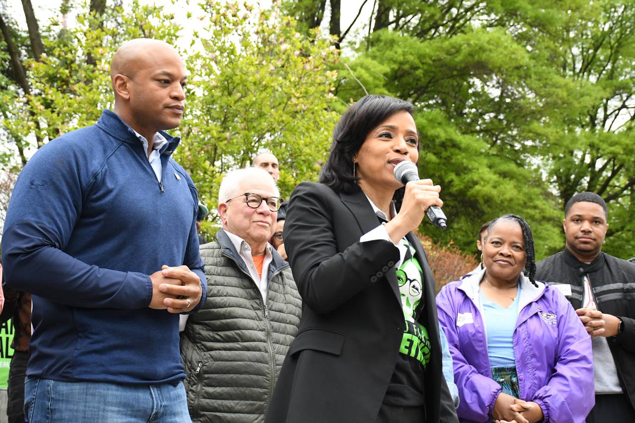 U.S. Senate candidate Angela Alsobrooks, center, speaks at an "All in for Alsobrooks" rally at Woodberry Park in Baltimore on Saturday, April 27, 2024. She was joined by current and former elected officials from the Baltimore area, including Gov. Wes Moore, at left.