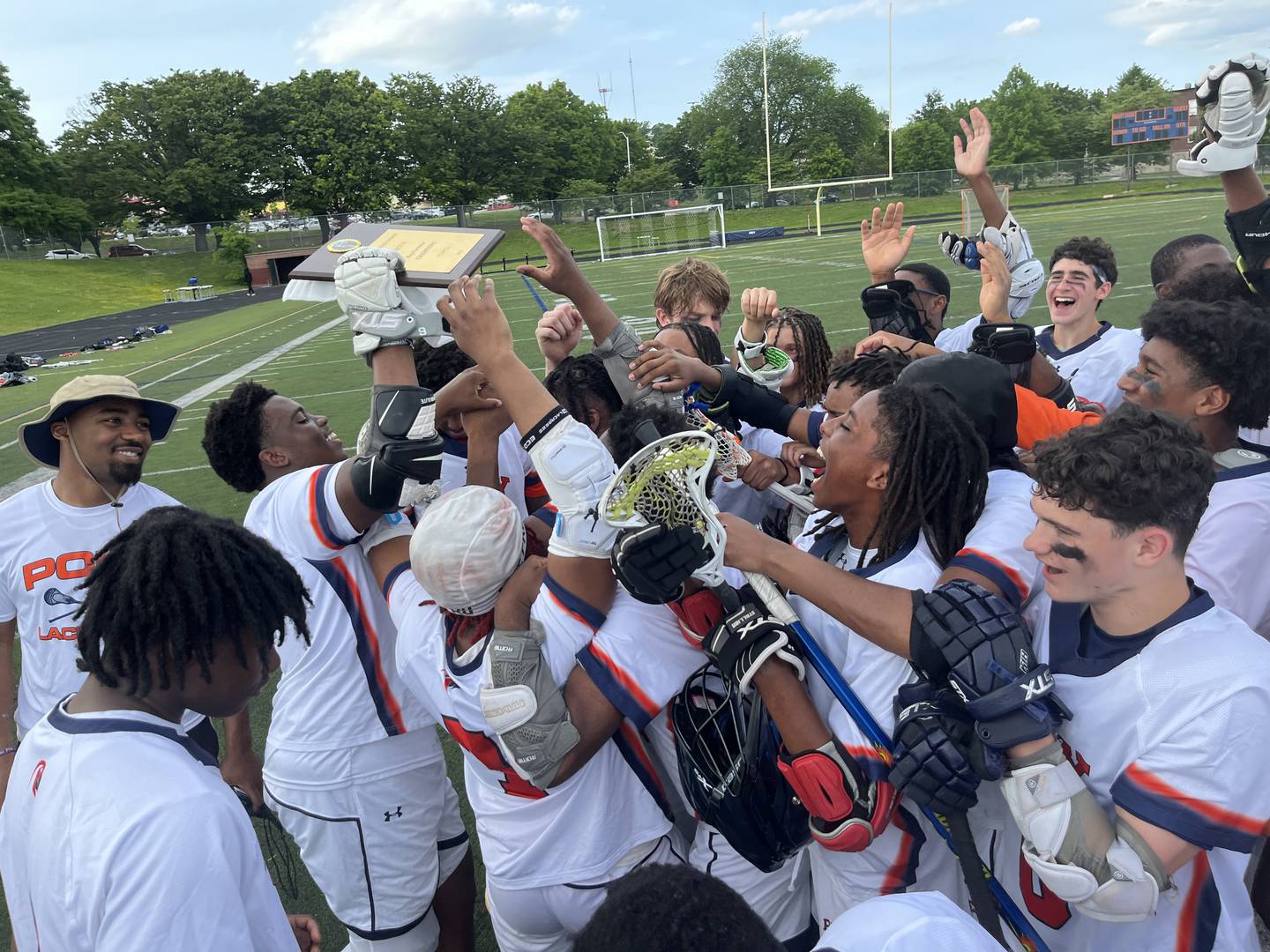 Poly boys lacrosse team celebrates as senior Ra-is Booth holds up the Baltimore City championship plaque. The Engineers won their second straight title with a 17-3 victory over City at Douglass.