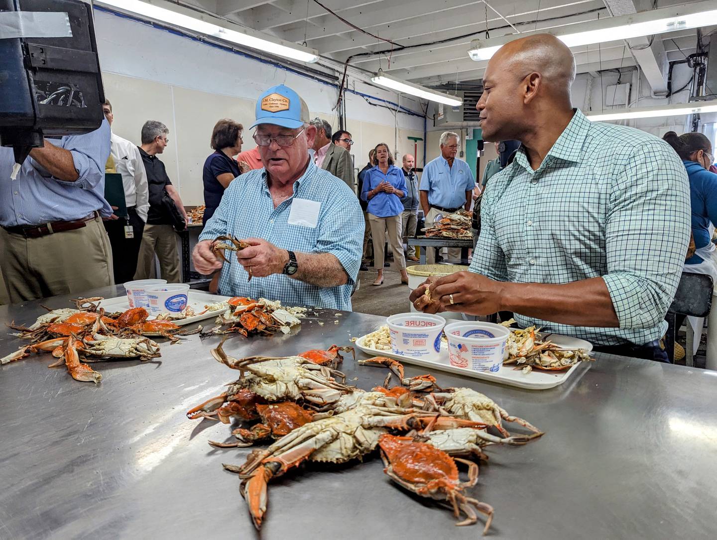 Gov. Wes Moore, right, and JM Clayton owner Jim Brooks pick crabs inside the seafood processing plant in Cambridge on Thursday, July 20, 2023.