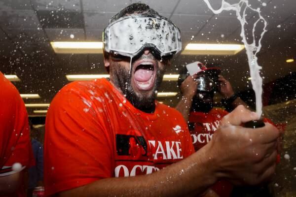 Baltimore Orioles taxi squad catcher José Godoy pops champagne in the clubhouse following the team’s playoff-clinching win against the Tampa Bay Rays on Sunday, September 17, 2023. The Orioles earned a spot in the playoffs for the first time since 2016.