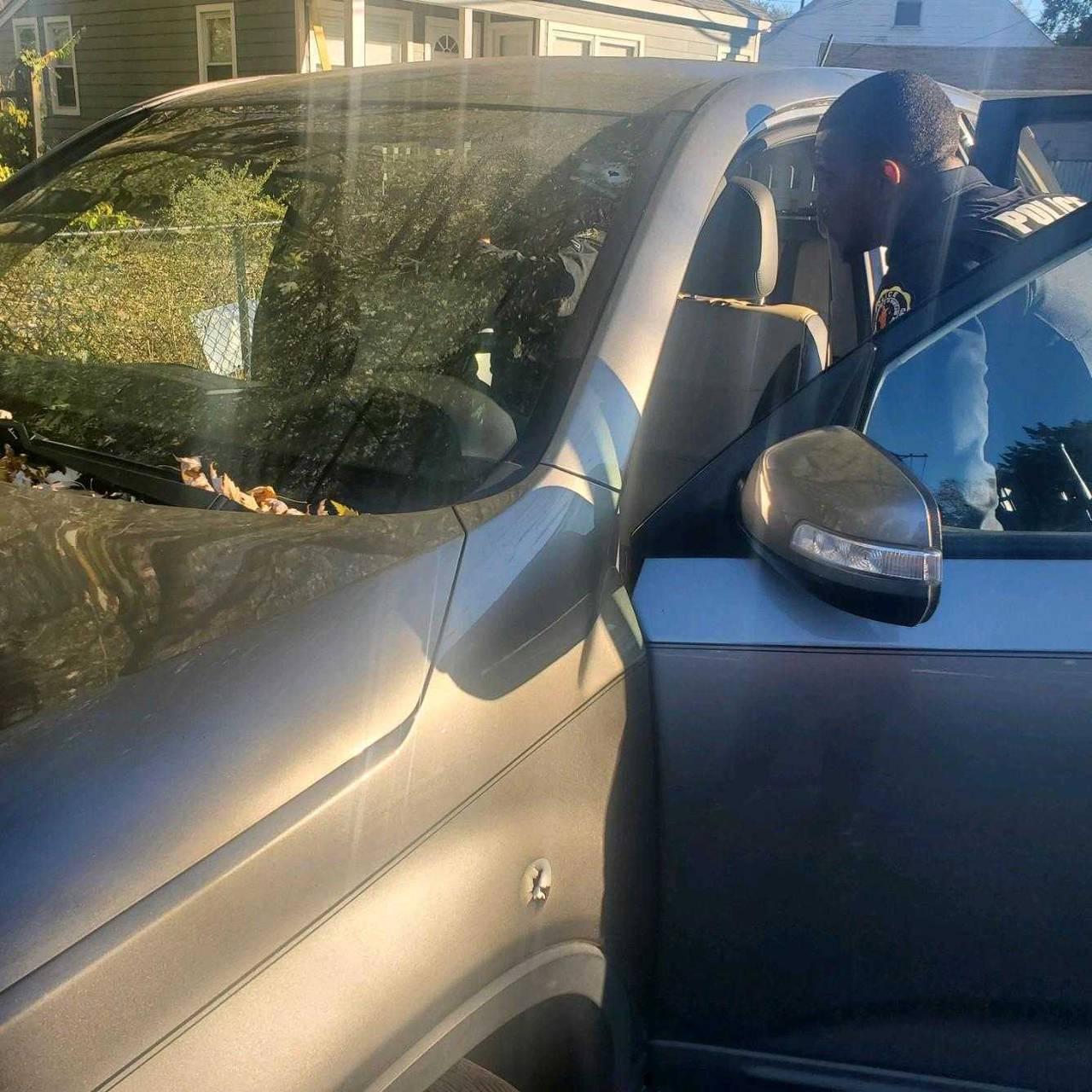 An Annapolis police officer checks inside a car struck by bullets in November on Madison Street.