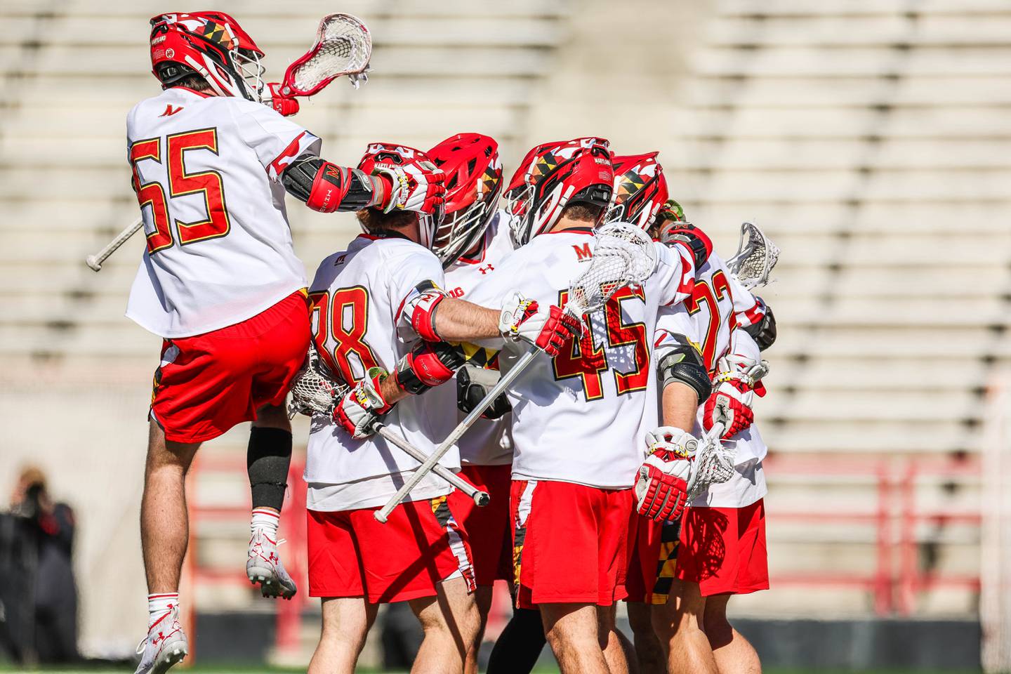 This picture shows several players from the University of Maryland men's lacrosse game gathering after a goal.