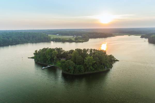 An aerial view of the island that shows the wooded areas and the dock.