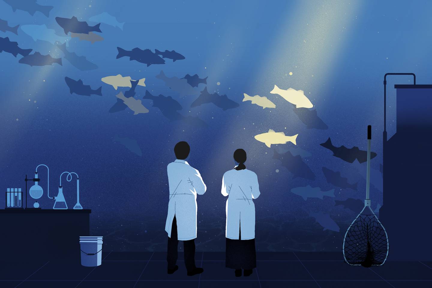 Two scientists and lab equipment in front of tank of fish