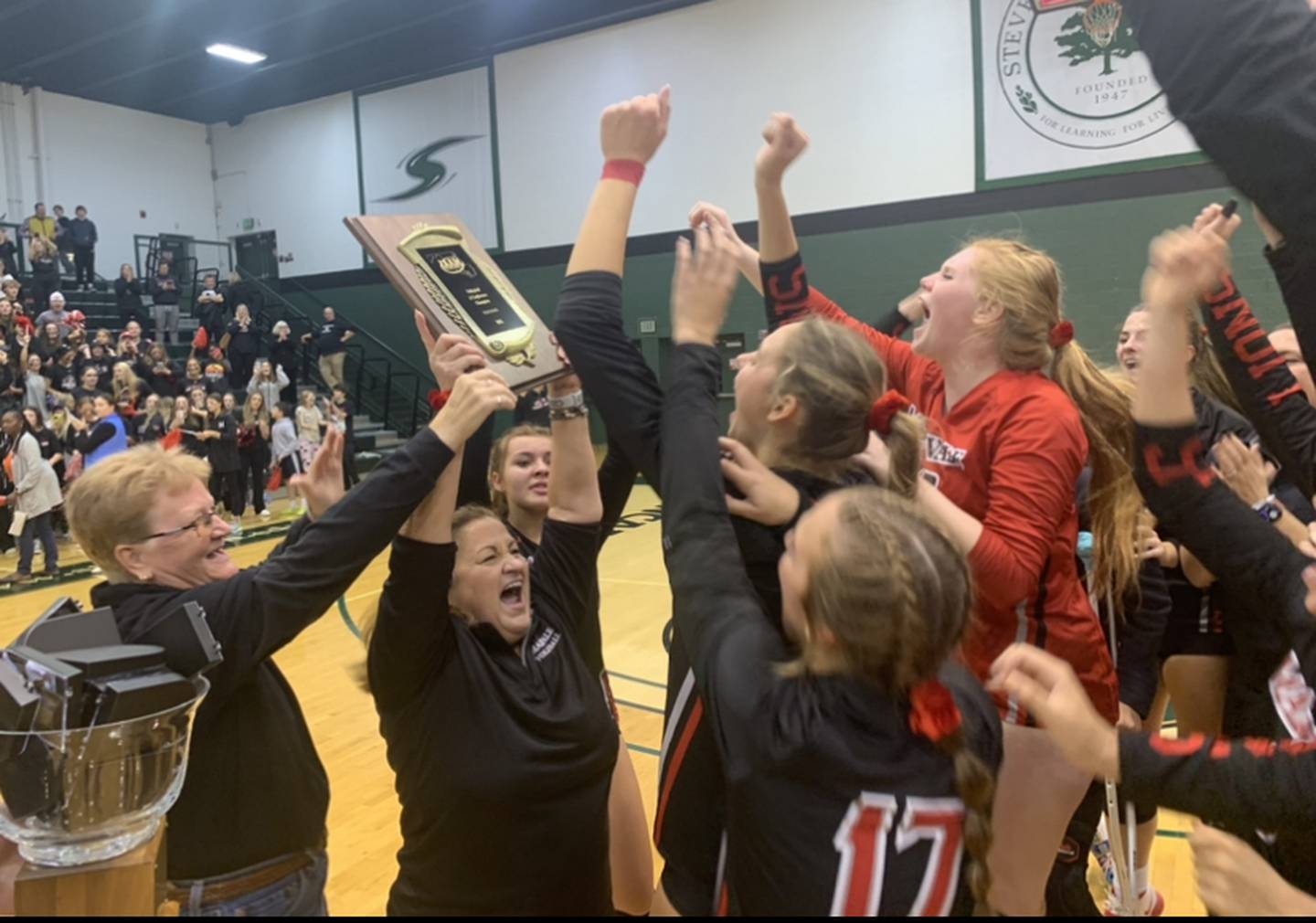 Maryvale Prep coach Missy Little holds up the IAAM A Conference volleyball championship plaque Sunday evening. The No. 7 Lions won their second straight crown with a four-set victory over sixth-ranked Archbishop Spalding at Stevenson University.